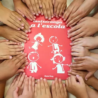 Alumnat fent una rotllana al voltant del quadern de Muixeranga a l'Escola